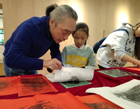 四川美术学院造型艺术学院金洪钢教授现场指导小朋友印制技术。主办方供图